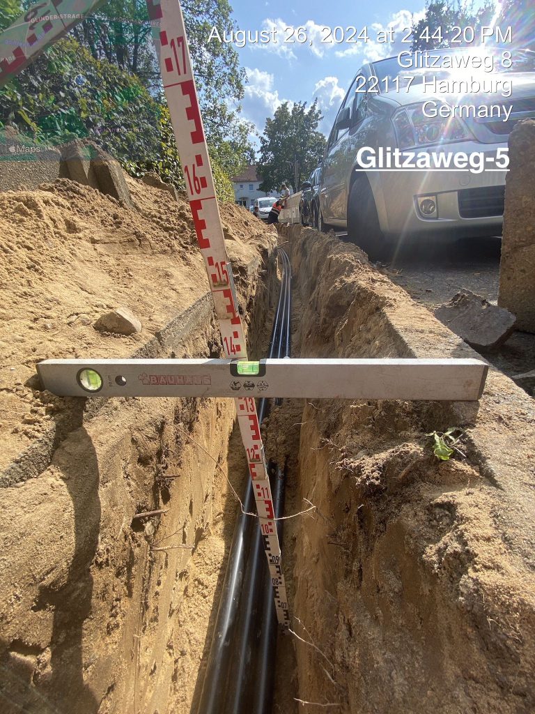 Baugrube mit Wasserwaage und Rohren